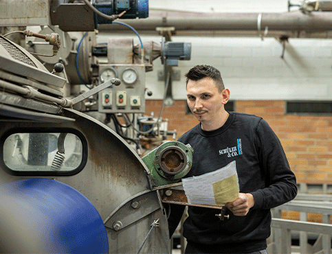 Hombre en máquina de acabado textil